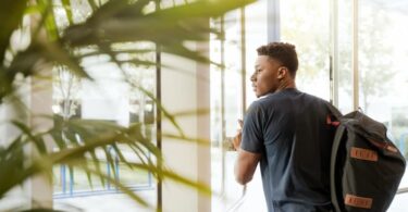 un jeune homme ouvre la porte d'une résidence étudiante