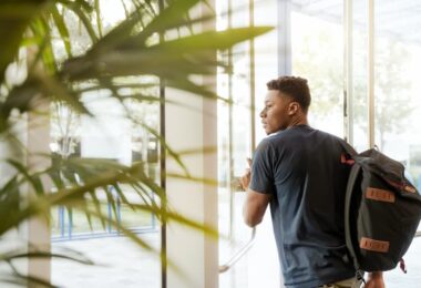 un jeune homme ouvre la porte d'une résidence étudiante
