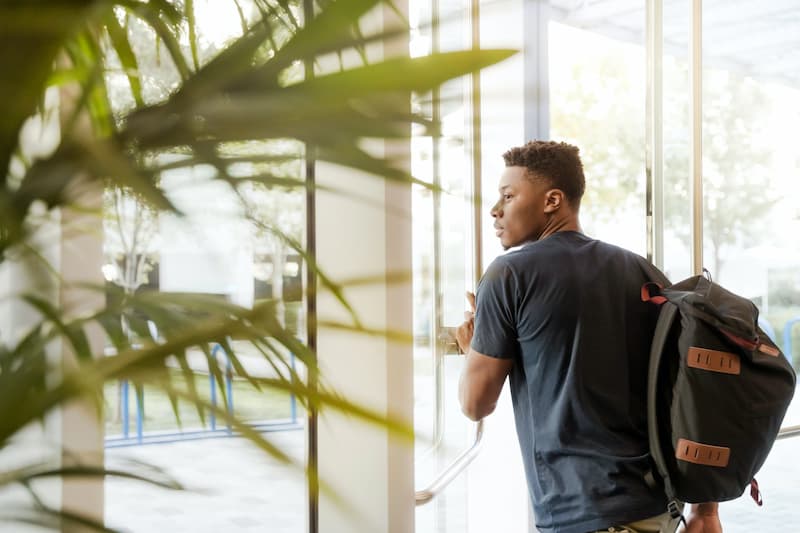 un jeune homme ouvre la porte d'une résidence étudiante